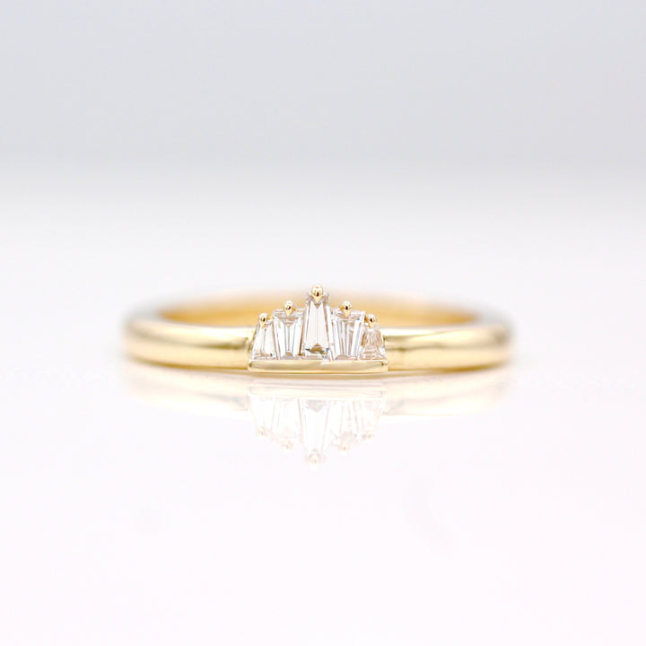 The True North Pinky Ring in Yellow Gold with 5 alternating tapered diamond baguettes on a neutral background