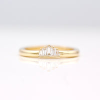The True North Pinky Ring in Yellow Gold with 5 alternating tapered diamond baguettes on a neutral background
