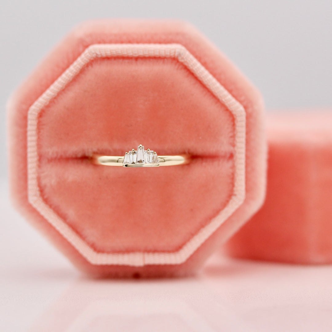 The True North Pinky Ring with diamond tapered baguettes in a peachy pink ring box