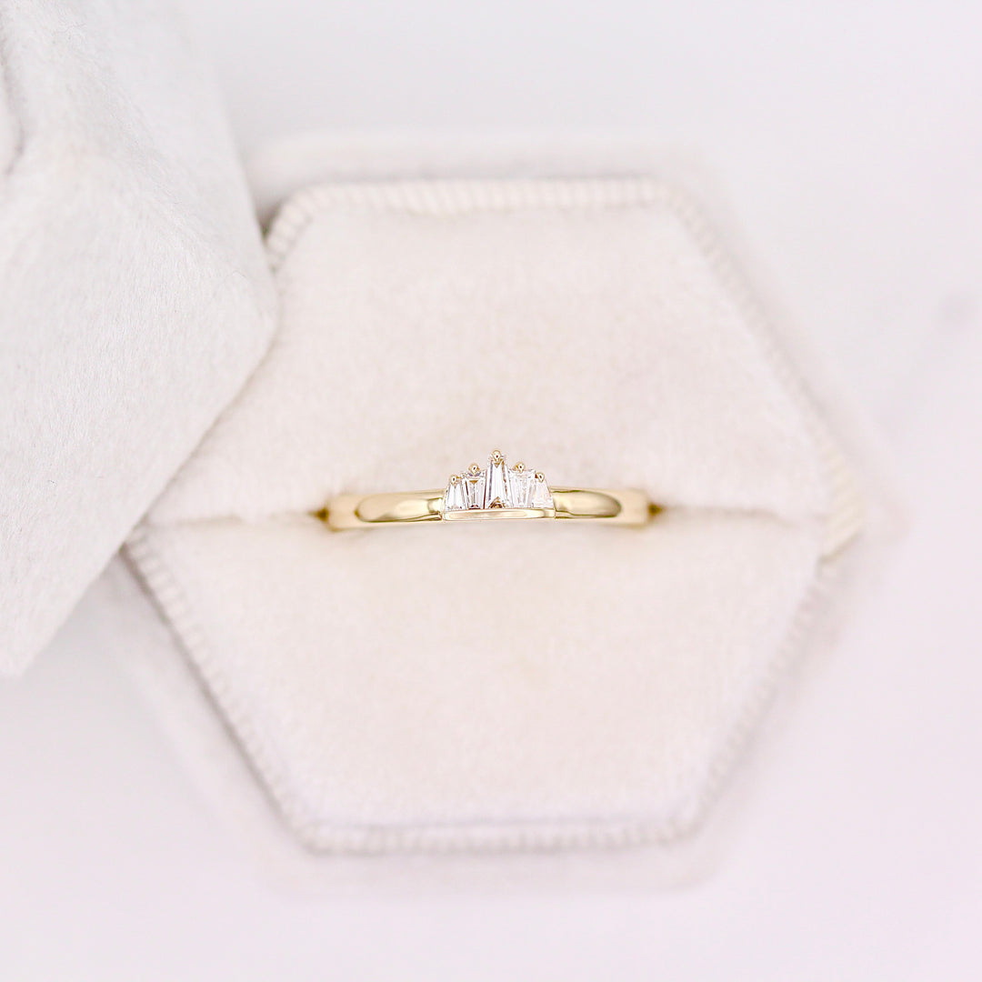 Yellow Gold diamond tapered baguette ring in a white velvet ring box with a neutral background 