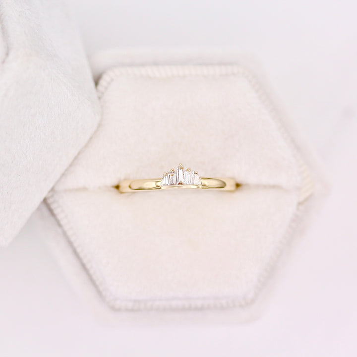 Yellow Gold diamond tapered baguette ring in a white velvet ring box with a neutral background 
