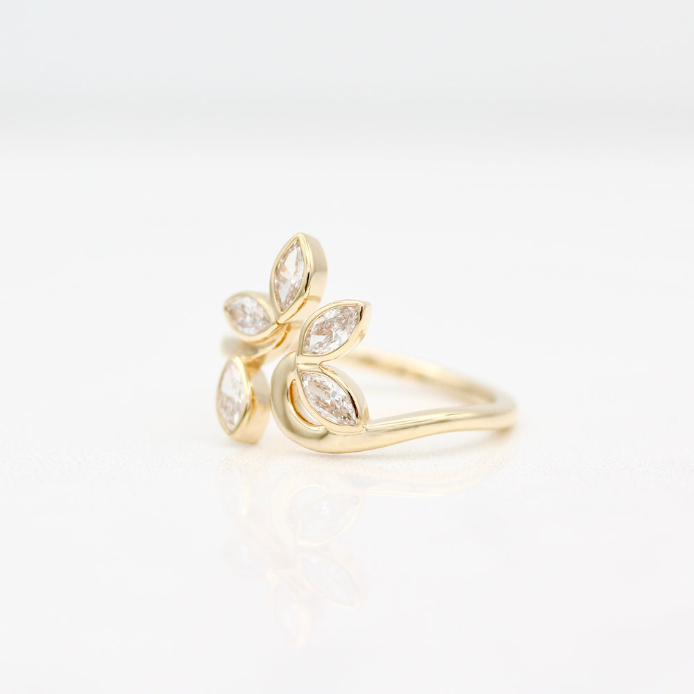 Yellow gold ring with marquise diamonds displayed at an angle