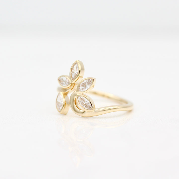 Yellow gold ring with marquise diamonds displayed at an angle