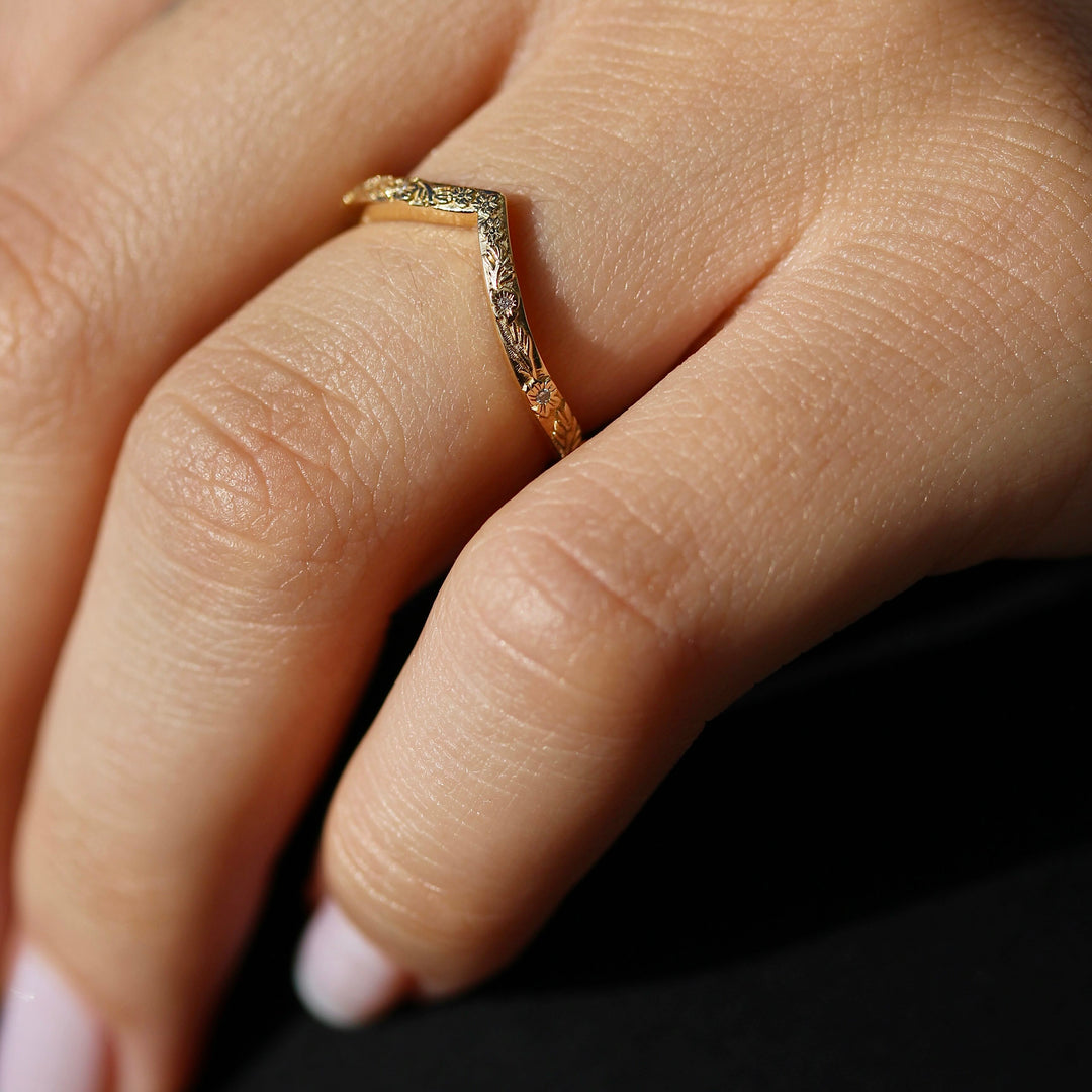 Yellow Gold V shaped Wedding Band with a Floral Design on a Hand.