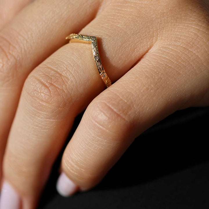 Yellow Gold V shaped Wedding Band with a Floral Design on a Hand.