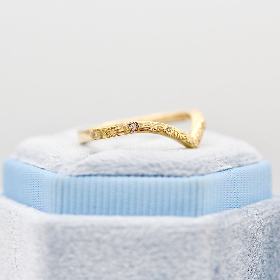 The Willow Wedding Band angled resting on a Blue Velvet Ring Box.