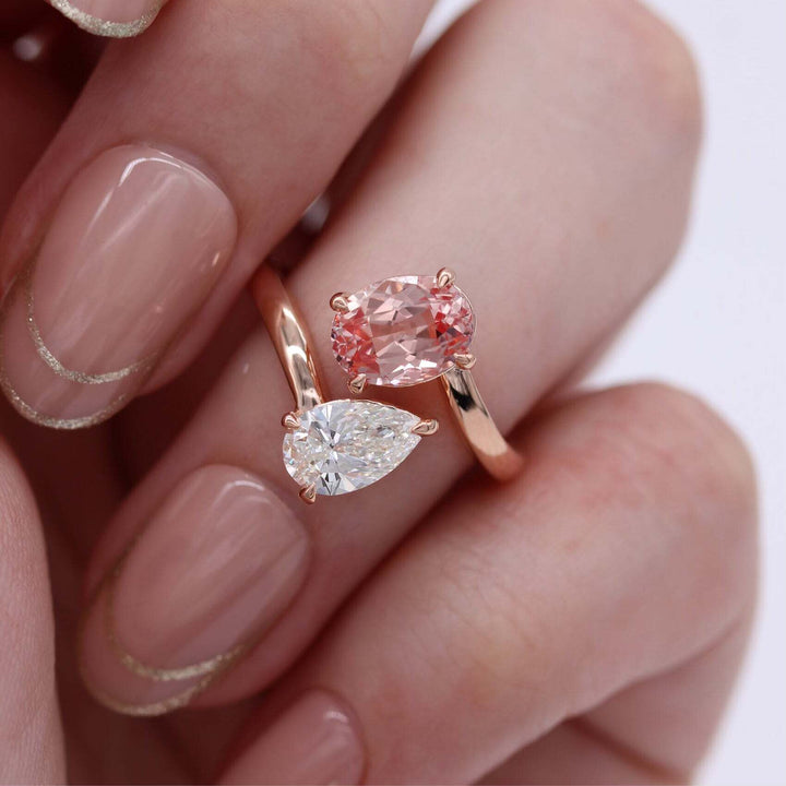 hand wearing Toi et Moi peachy-pink sapphire and diamond ring