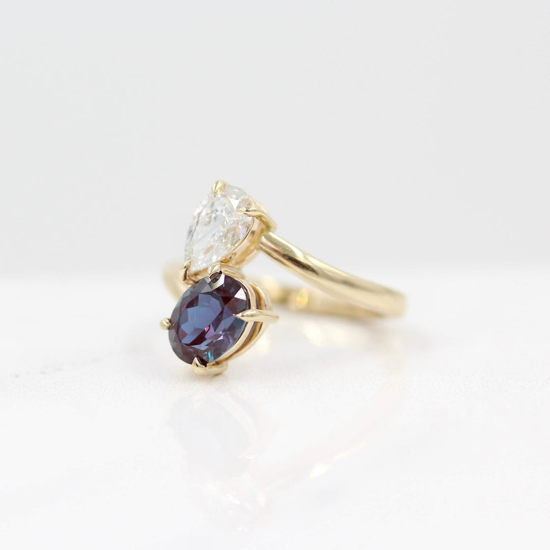 Toi et Moi Diamond and Alexandrite Bypass Ring in yellow gold against a white background