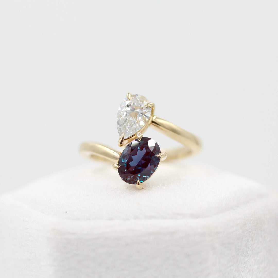 Toi et Moi Diamond and Alexandrite Bypass Ring in yellow gold atop a white velvet ring box