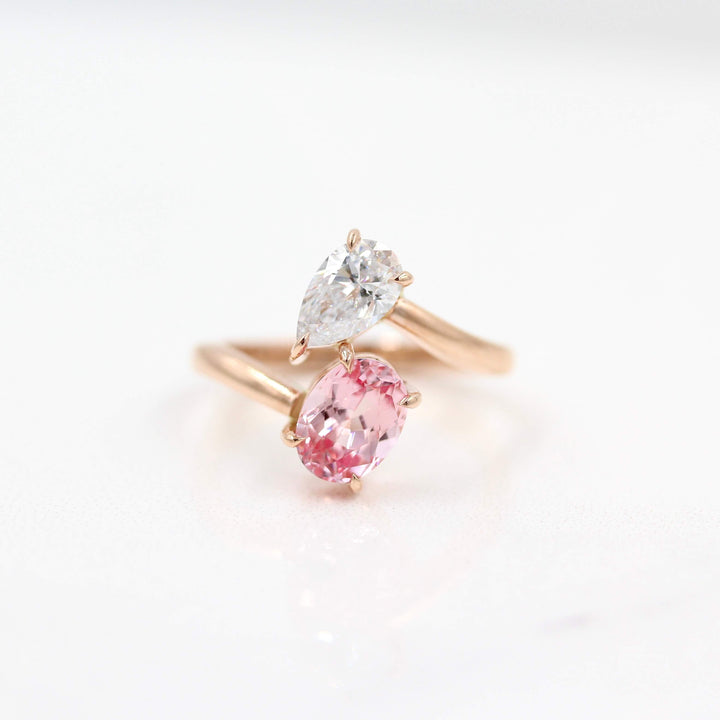 Toi et Moi Diamond and Peachy-Pink Sapphire Bypass Ring in Rose Gold against a white background