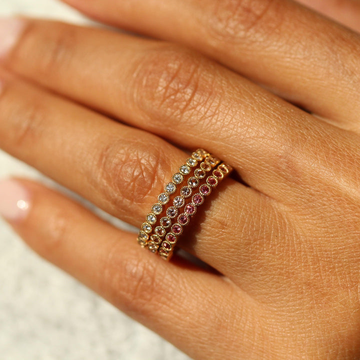 The April Florence Birthstone Wedding Band with Lab-Grown Diamond in Yellow Gold stacked with the June Florence Birthstone Wedding Band with Alexandrite in Yellow Gold and the January Florence Birthstone Wedding Band with Padparadscha Sapphire in Yellow Gold modeled