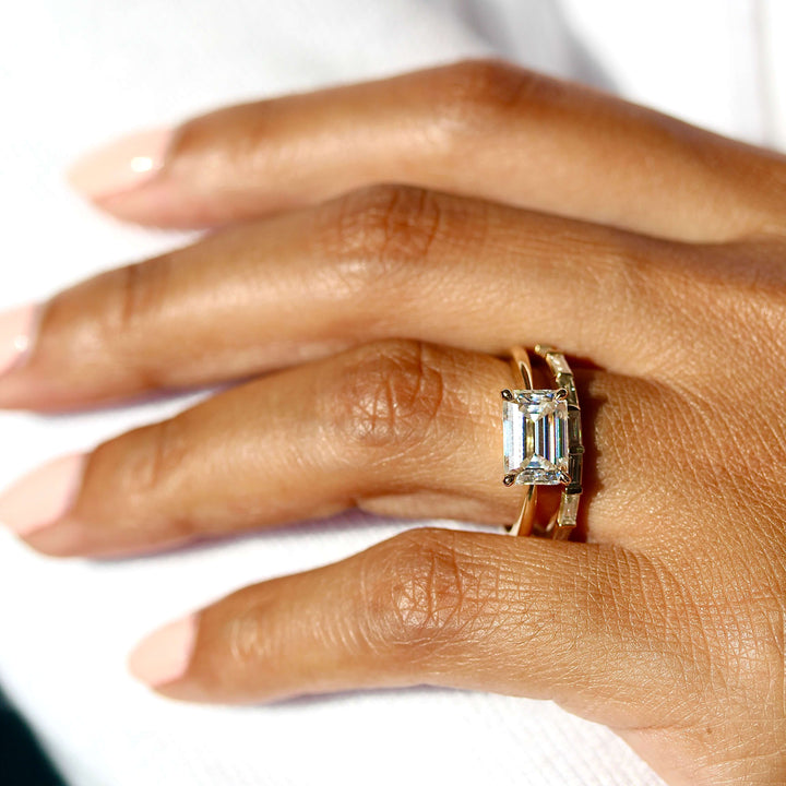 hand wearing the twyla ring emerald stacked with a wedding band