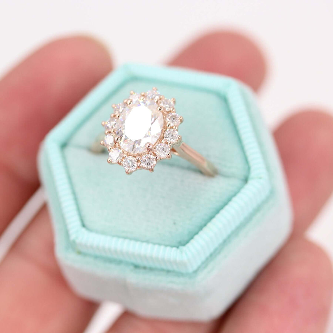 allie sunburst halo engagement ring in a teal ring box