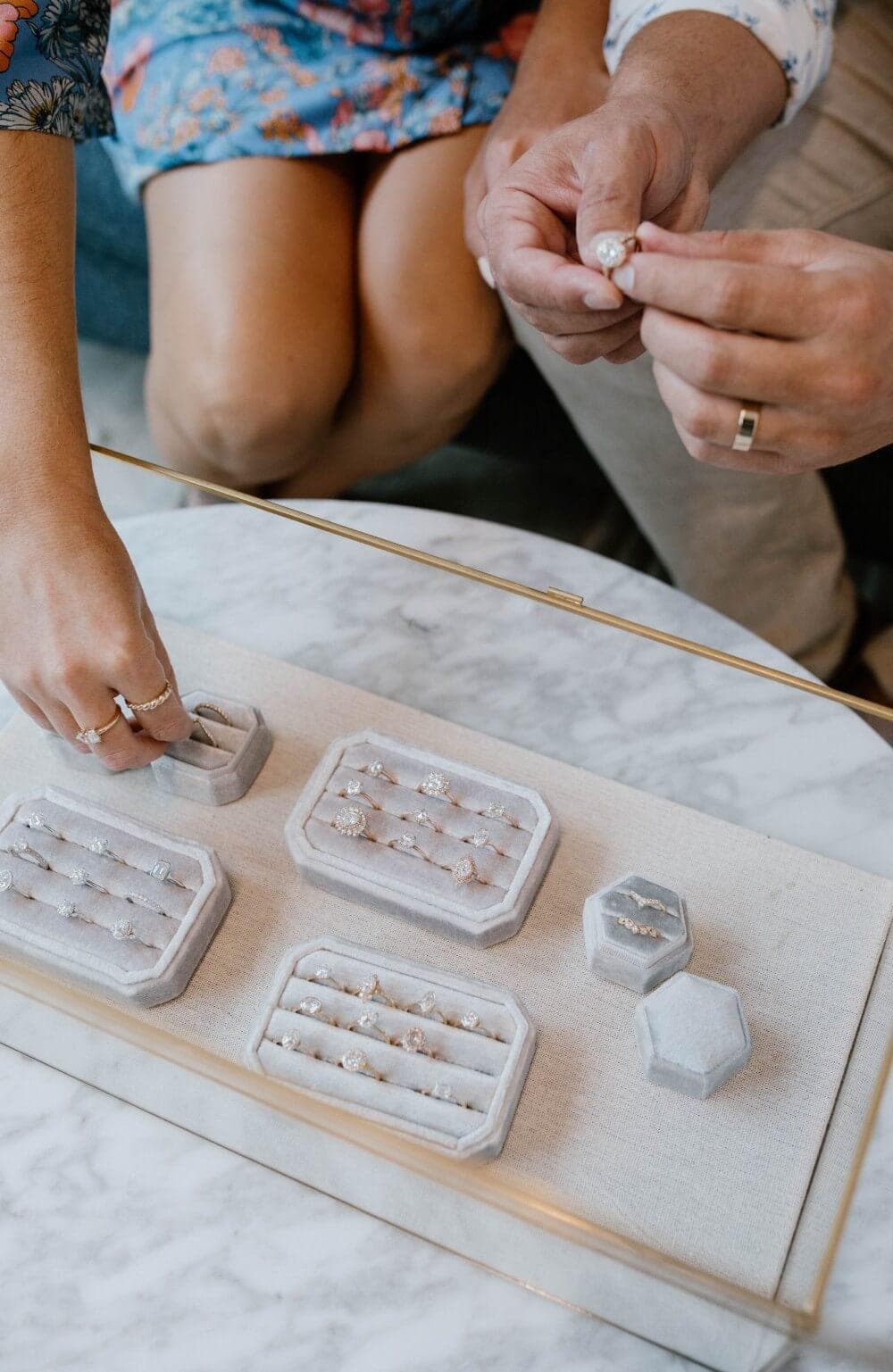 Hands picking up engagement rings
