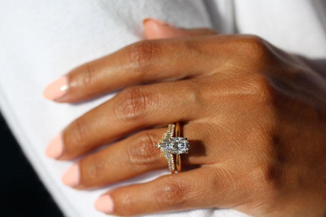 Hand wearing lab-grown diamond solitaire and contour wedding band