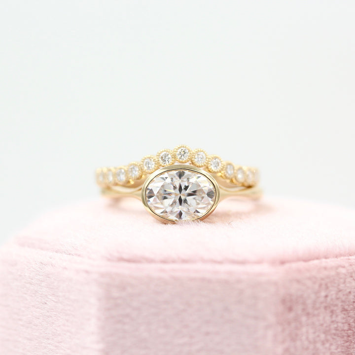 The Stevie (East-West Oval) Ring in yellow gold stacked with the Florence Contour Band in yellow gold on a pink velvet ring box 