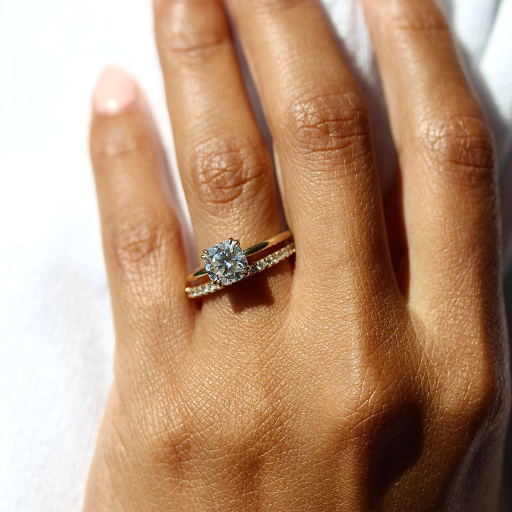a model wearing a round engagement ring with a pavé band