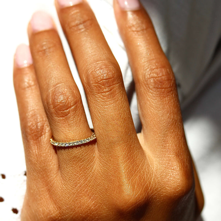 a model wearing a gold pavé wedding band