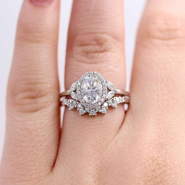 an oval halo engagement ring and curved wedding band stack.
