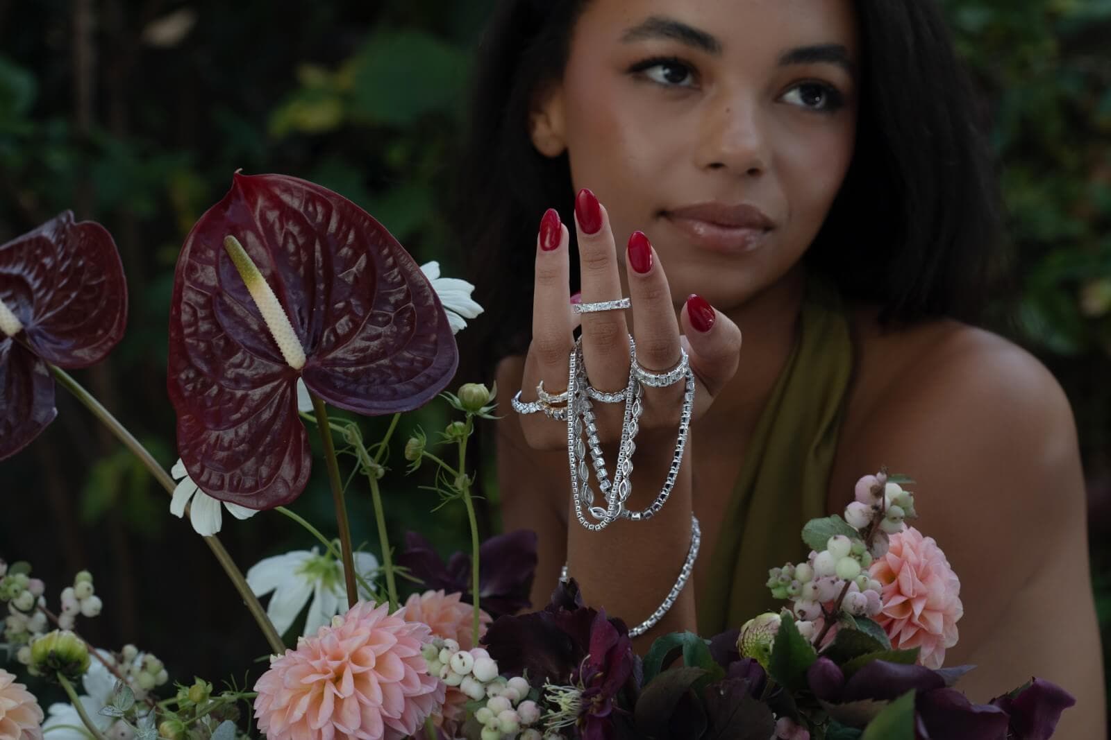 model wearing rings and holding diamond tennis bracelets