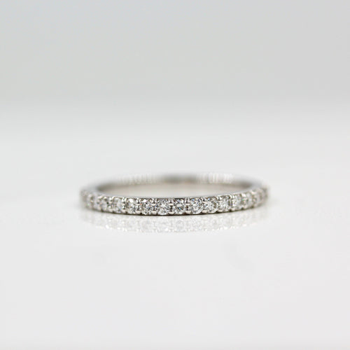 a silver pavé wedding band on white surface
