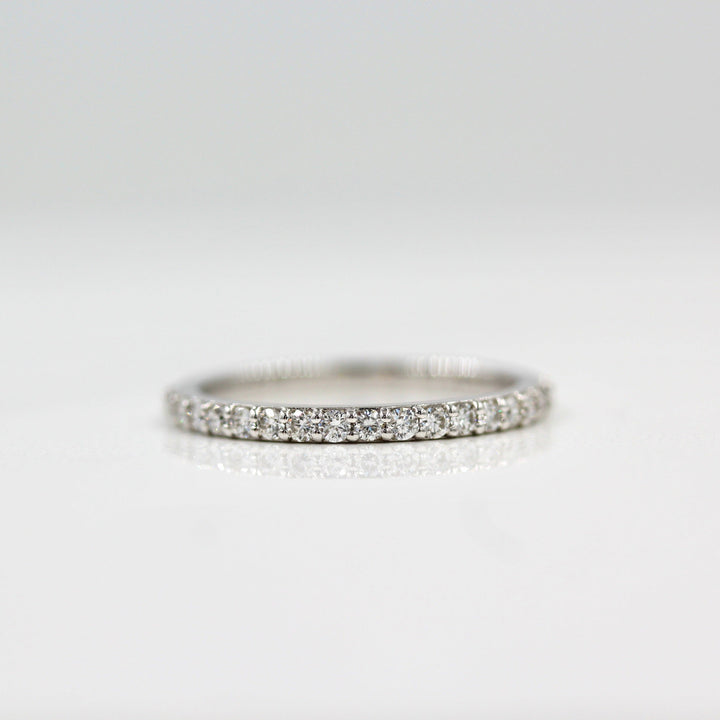 a silver pavé wedding band on white surface