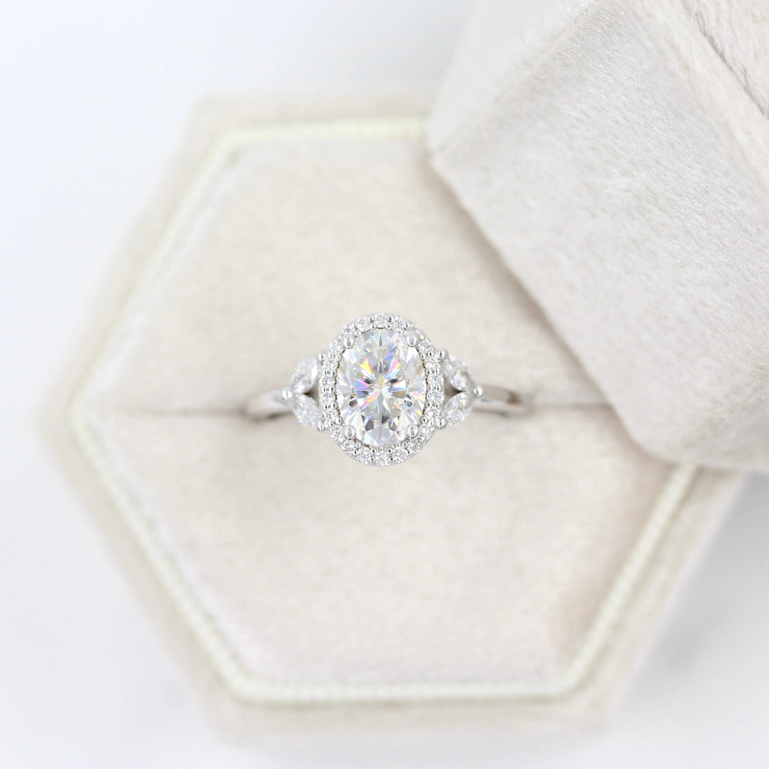 a white gold oval engagement ring in a ring box.