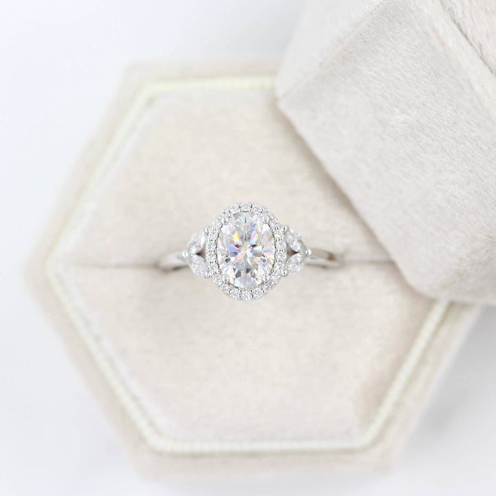 a white gold oval engagement ring in a ring box.