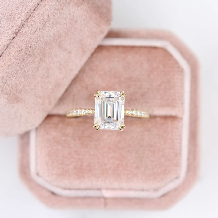 Pink velvet box holding emerald cut engagement ring