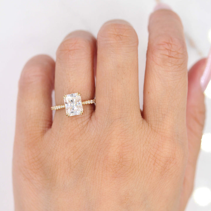 Hand wearing radiant engagement ring