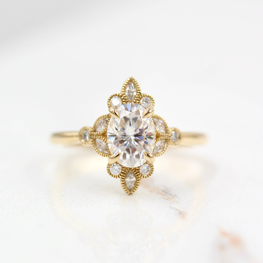 Oval moissanite halo engagement ring with marquise and round milgrain bezels