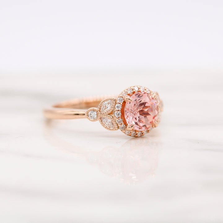 Side View of Peach-Pink Sapphire Engagement Ring with Round and Marquise Diamonds