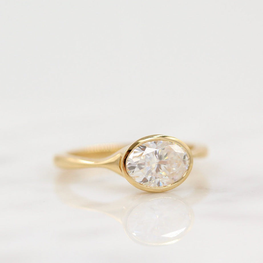 The Stevie Ring (East-West Oval) in yellow gold against a white background