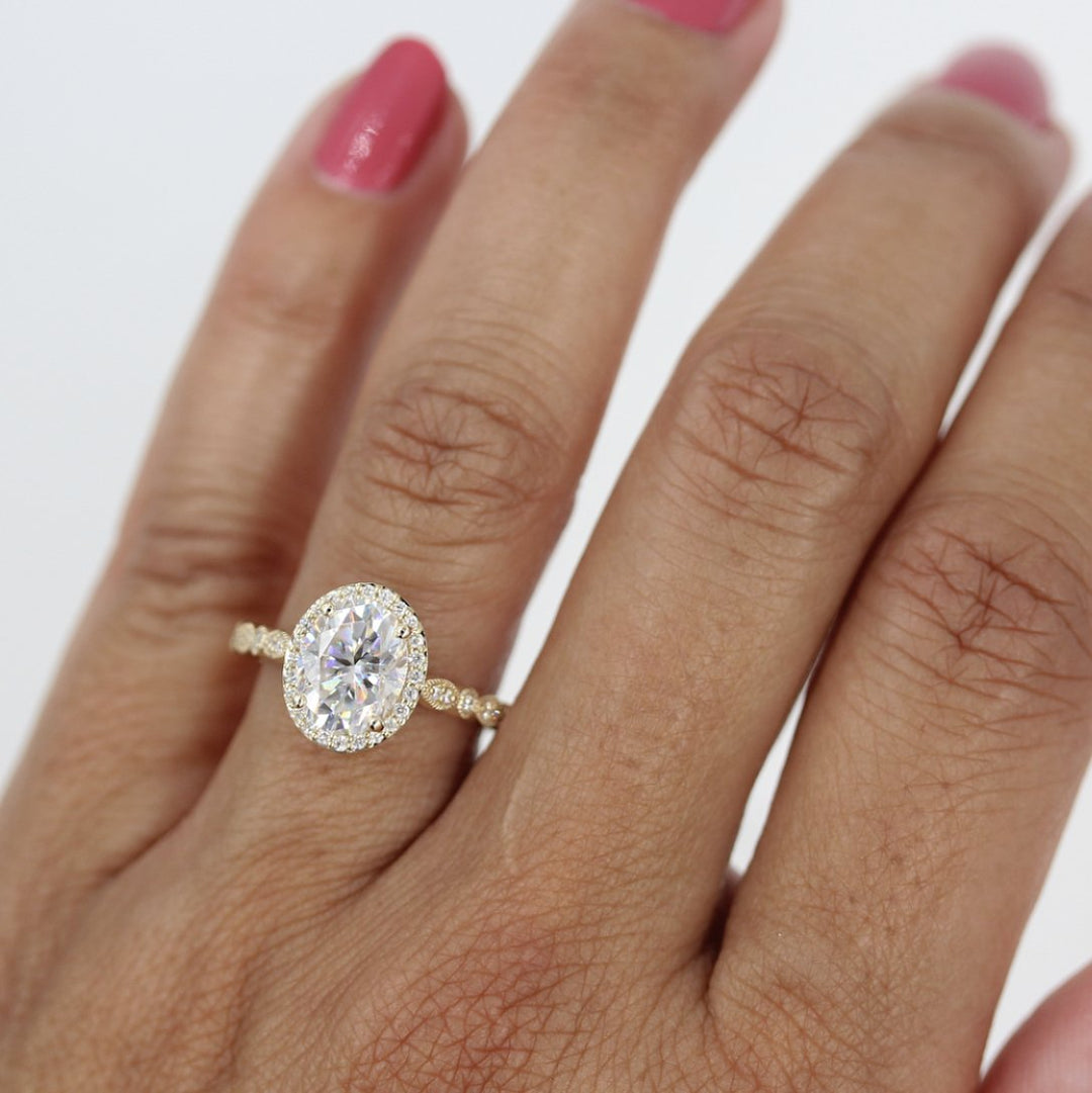 Hand wearing 2ct oval moissanite halo engagement ring