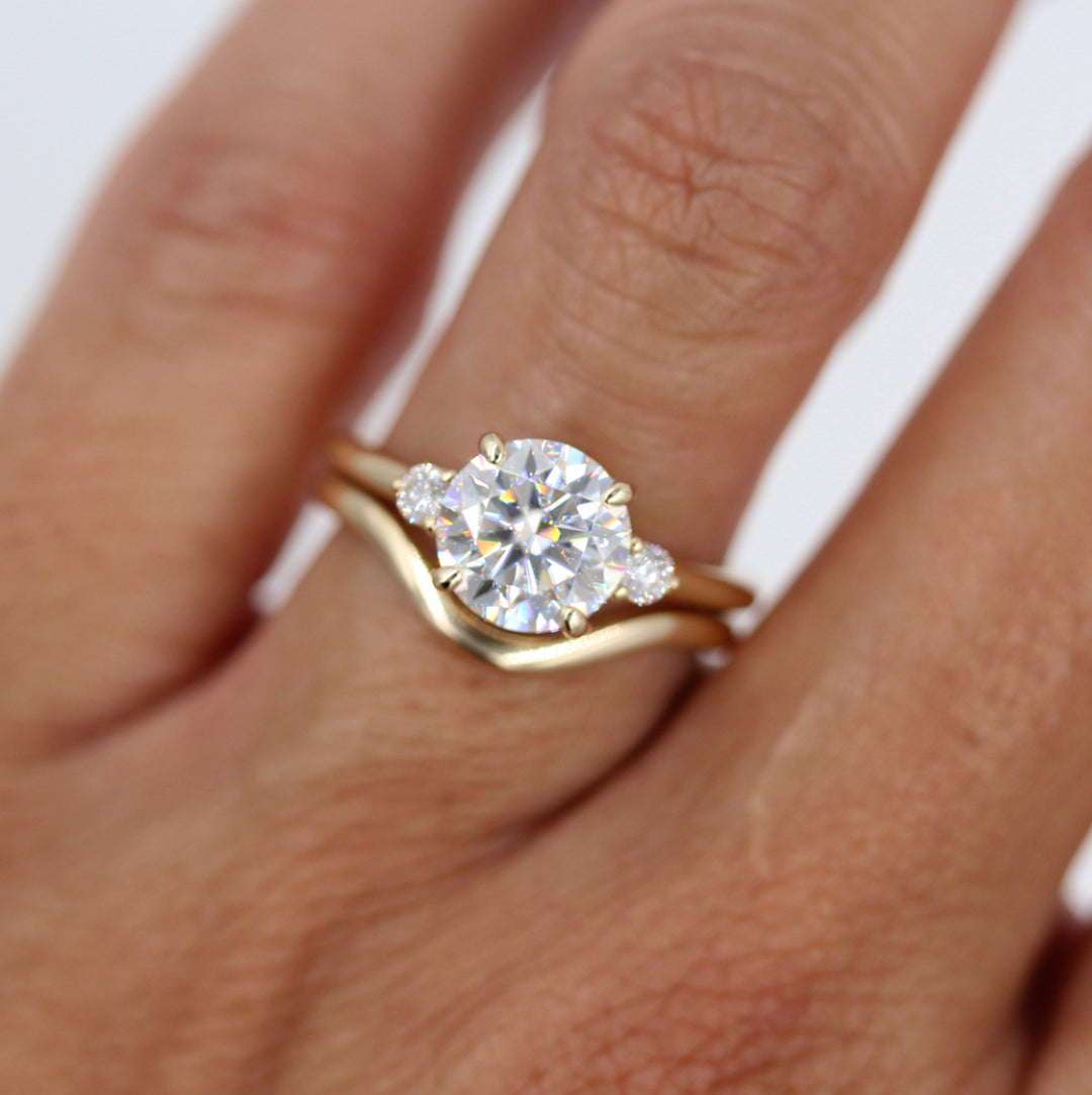Yellow gold lab-grown diamond engagement ring with yellow gold wave band worn underneath
