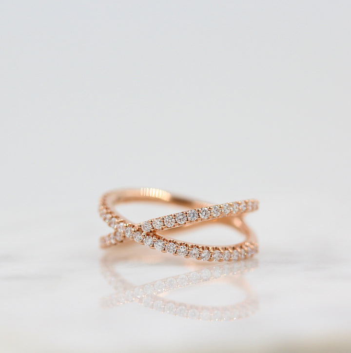 A criss-cross lab-grown diamond ring in rose gold, pictured at an angle