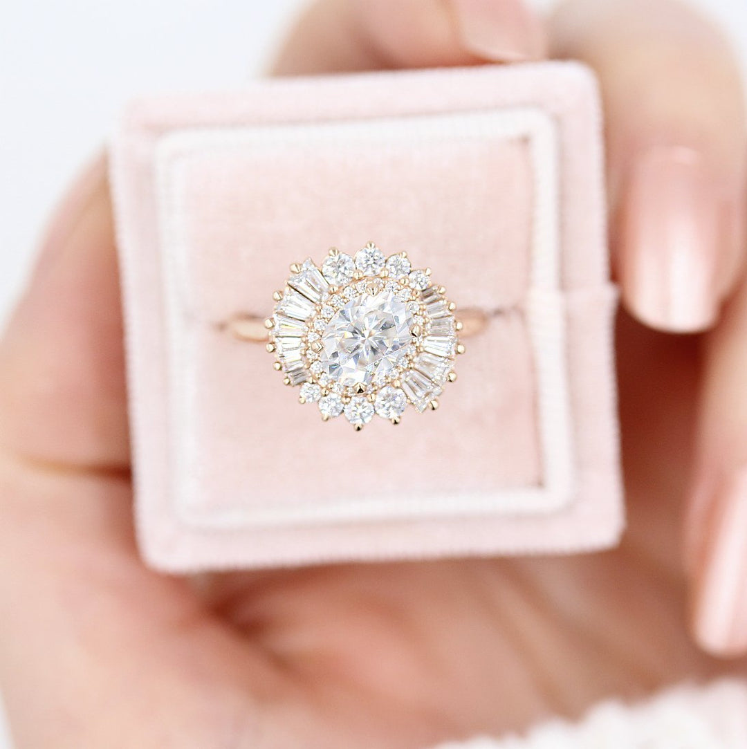 The Soleil Ring in Rose Gold and Moissanite in a pink velvet ring box held by a hand