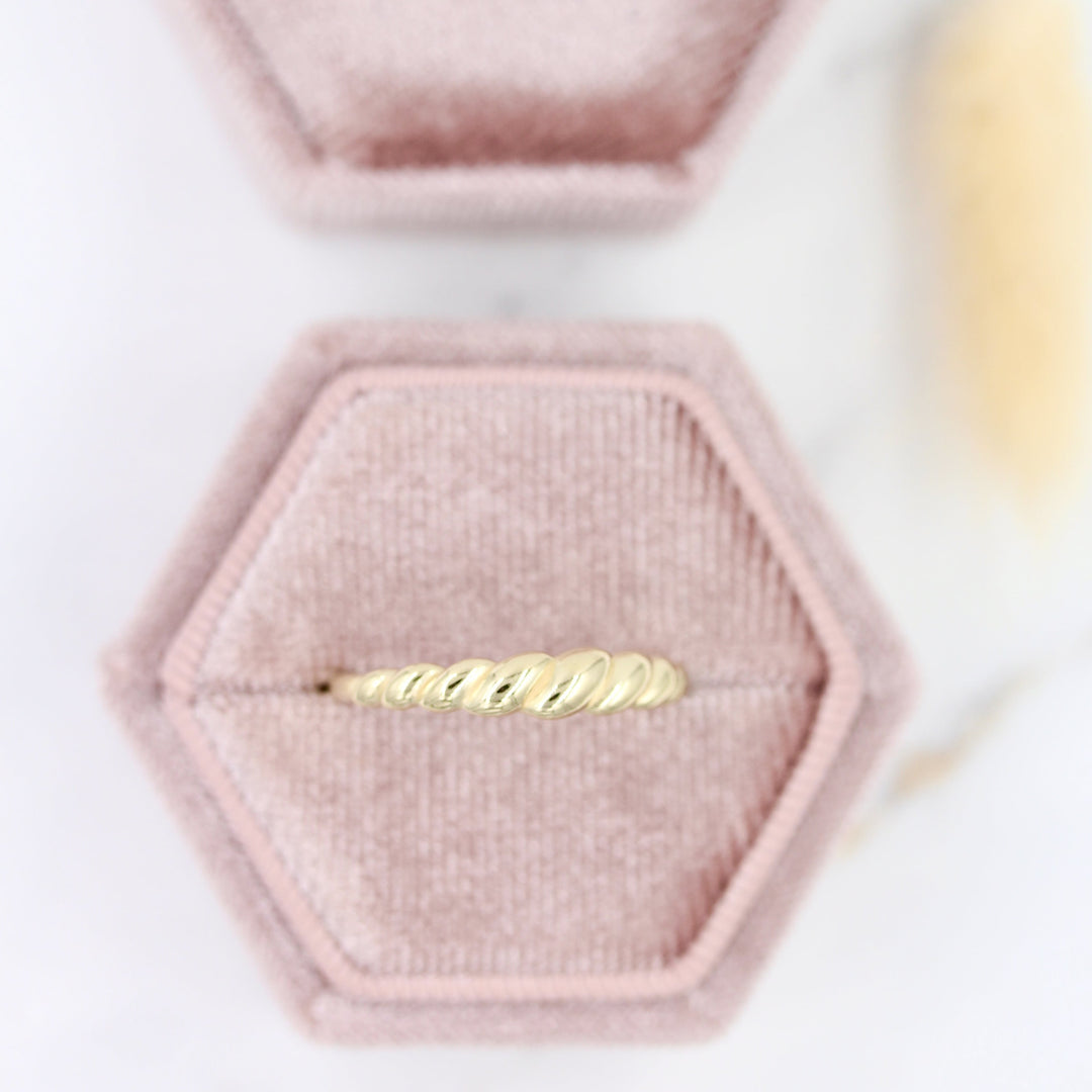 Rope style gold croissant ring in rose-colored velvet box