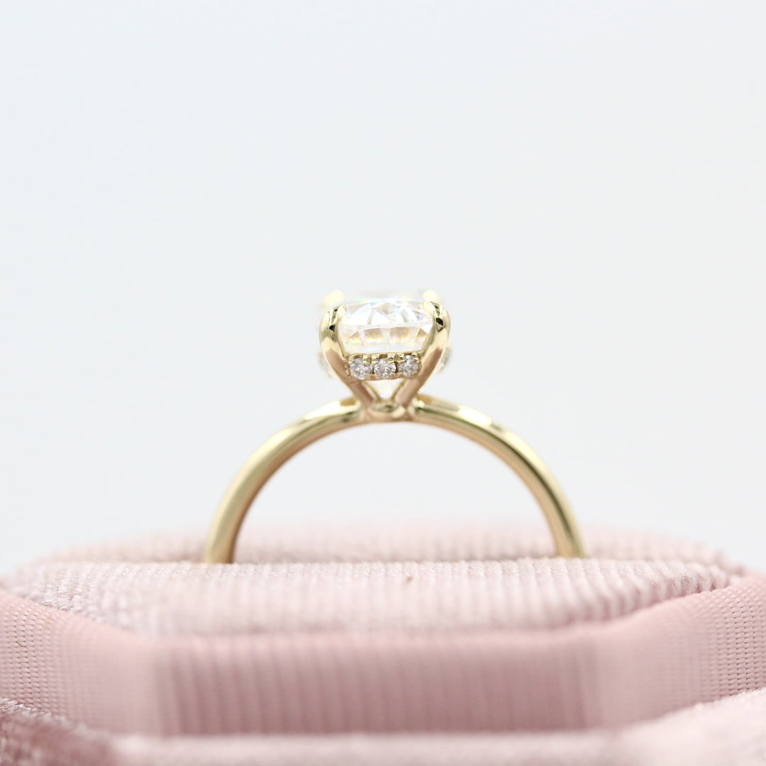 Pink velvet ring box holding 2ct oval engagement ring with hidden halo