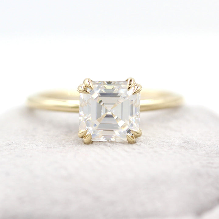 Asscher moissanite solitaire engagement ring on grey velvet box