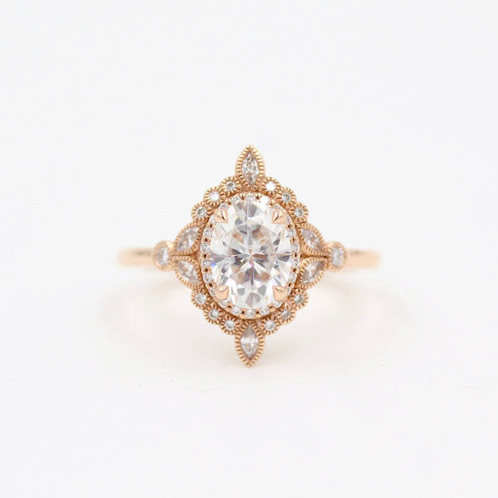 Intricate vintage-style halo engagement ring with milgrain details in rose gold