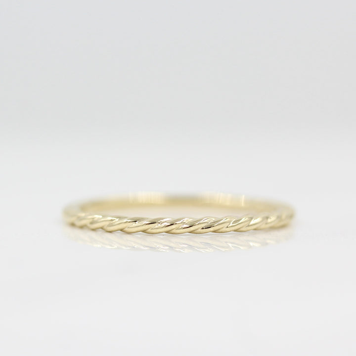 Dainty Twist Stacking ring in yellow gold against white background