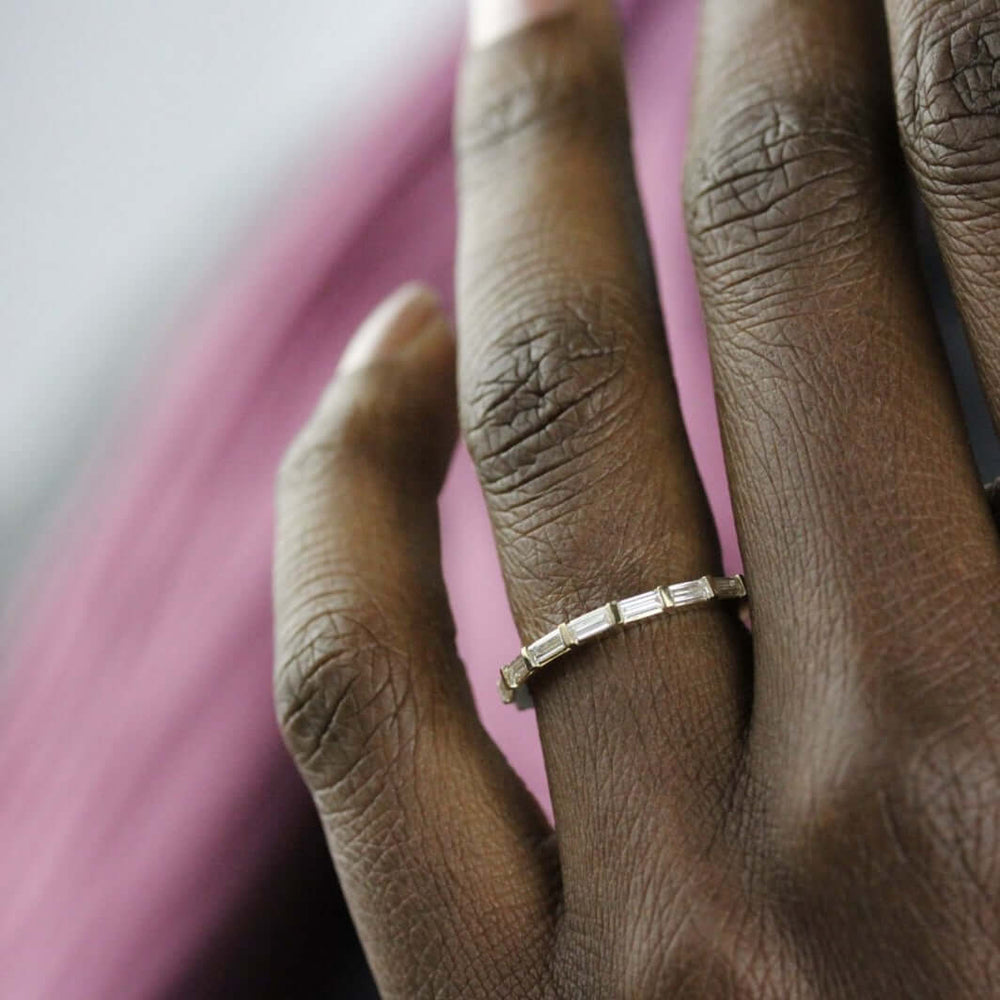 Close-up hand shot of the Horizon vintage baguette wedding band