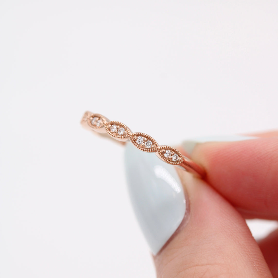 a model holding a rose gold scalloped wedding band