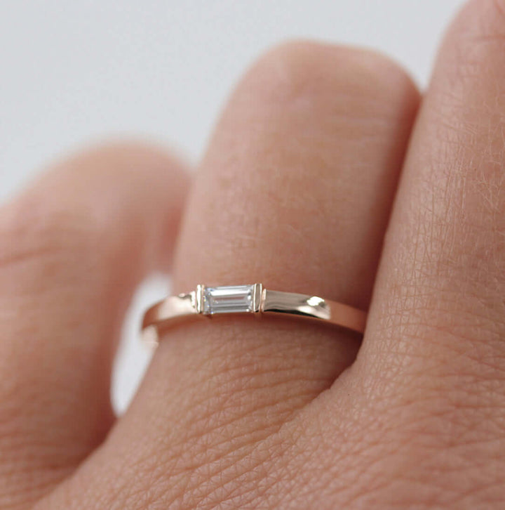 a model wearing a rose gold baguette diamond ring