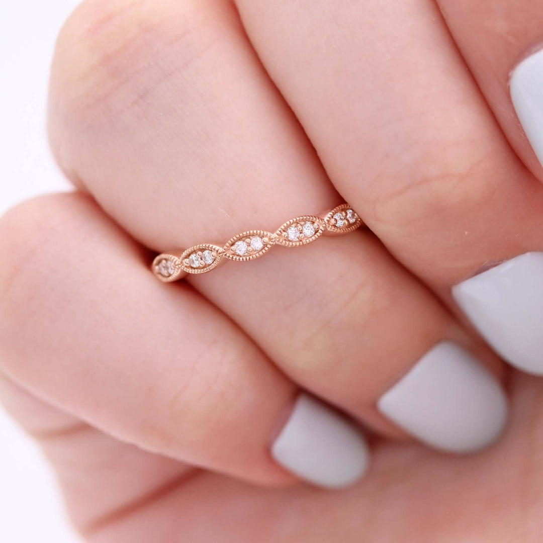 a model wearing a rose gold scalloped wedding band