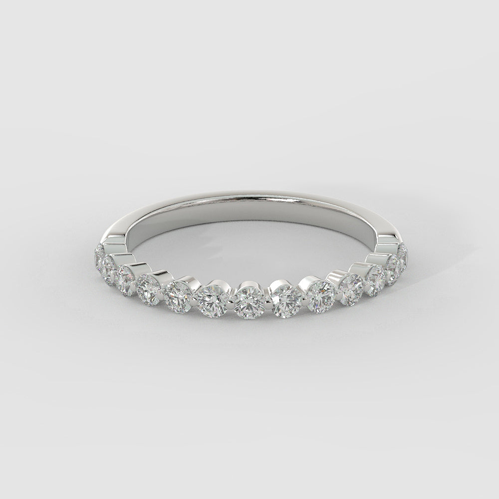 a white gold diamond ring on a white surface